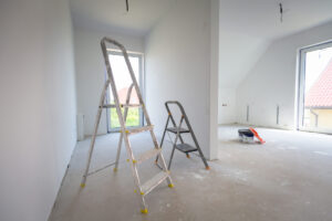 An empty room with some step ladders in the center. You can use this room for any way you see fit.