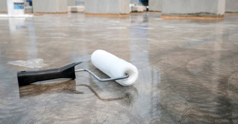 Epoxy Resin is used on the floor in this home remodeling project. A paint roller is near the center of the image.